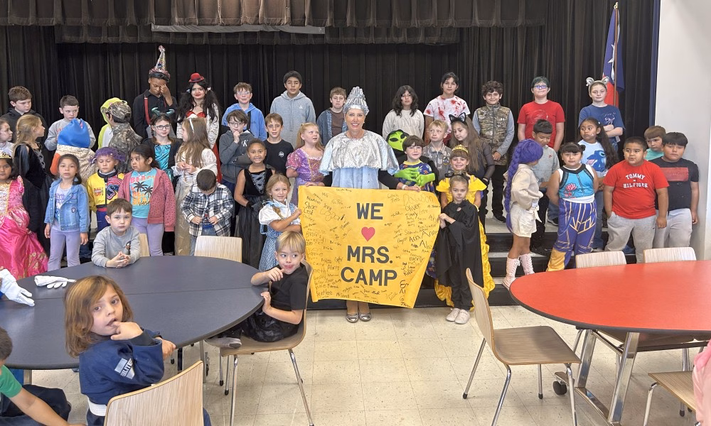 Crenshaw School students in costume applaud Principal Traci Camp during a surprise celebration for National Principals Month.
