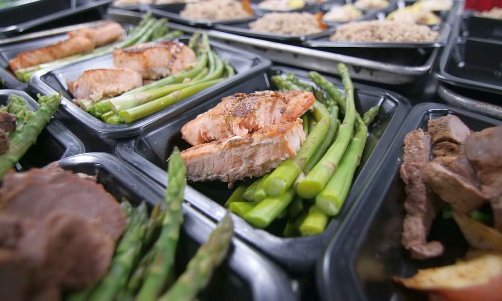 a group of meats and vegetables on a grill