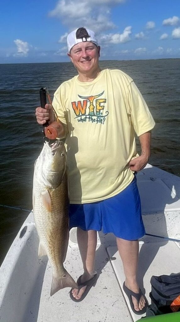 young man holding a redfish