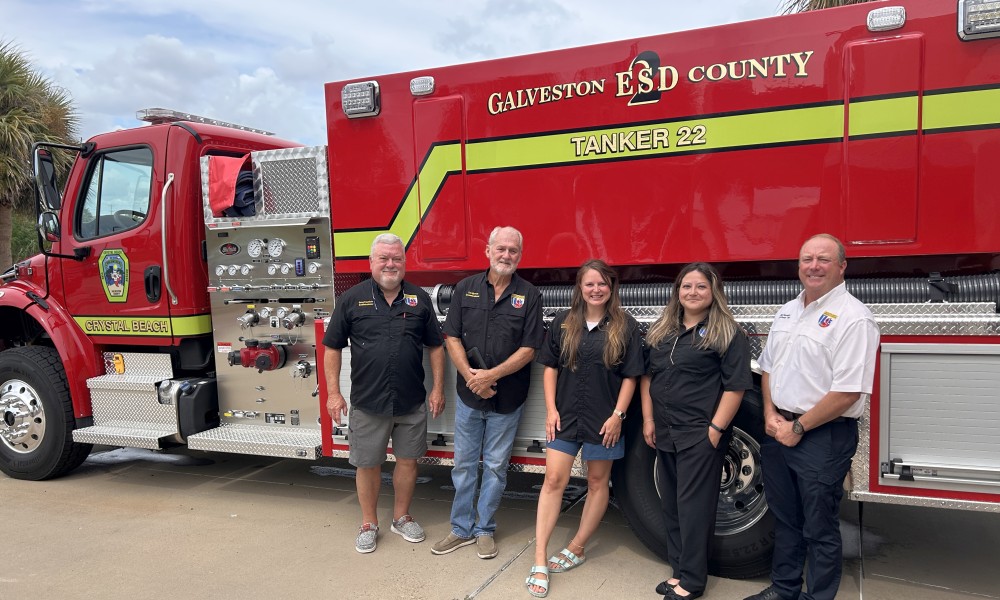 individuals standing in front of a new fire truck