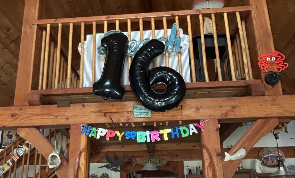 Happy Birthday sign and number 16 baloons