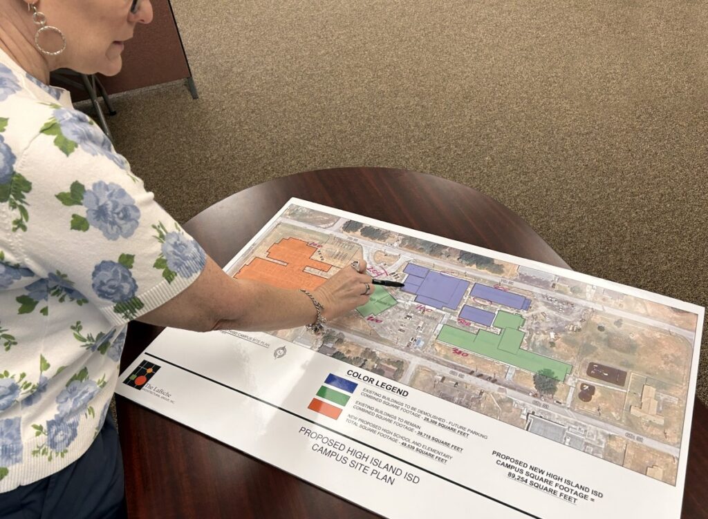 school administrator pointing to map of new construction