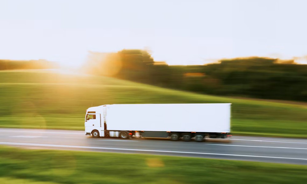 white semi truck driving down a rural road