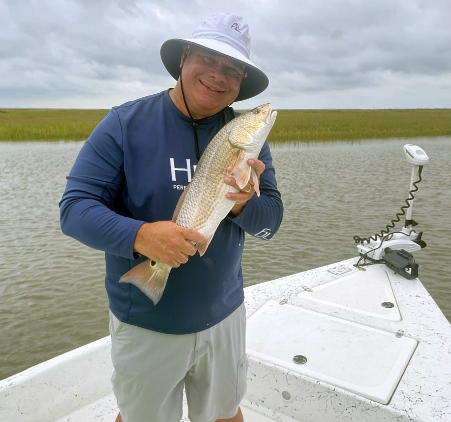 Man on boat holding a redfish
