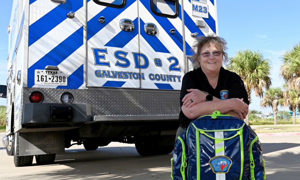 Dawn Blashill in front of ambulance leaning on backpack